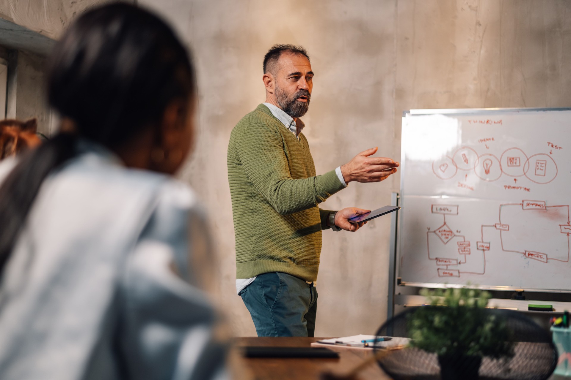 Mature businessman presenting business strategy to his interracial team